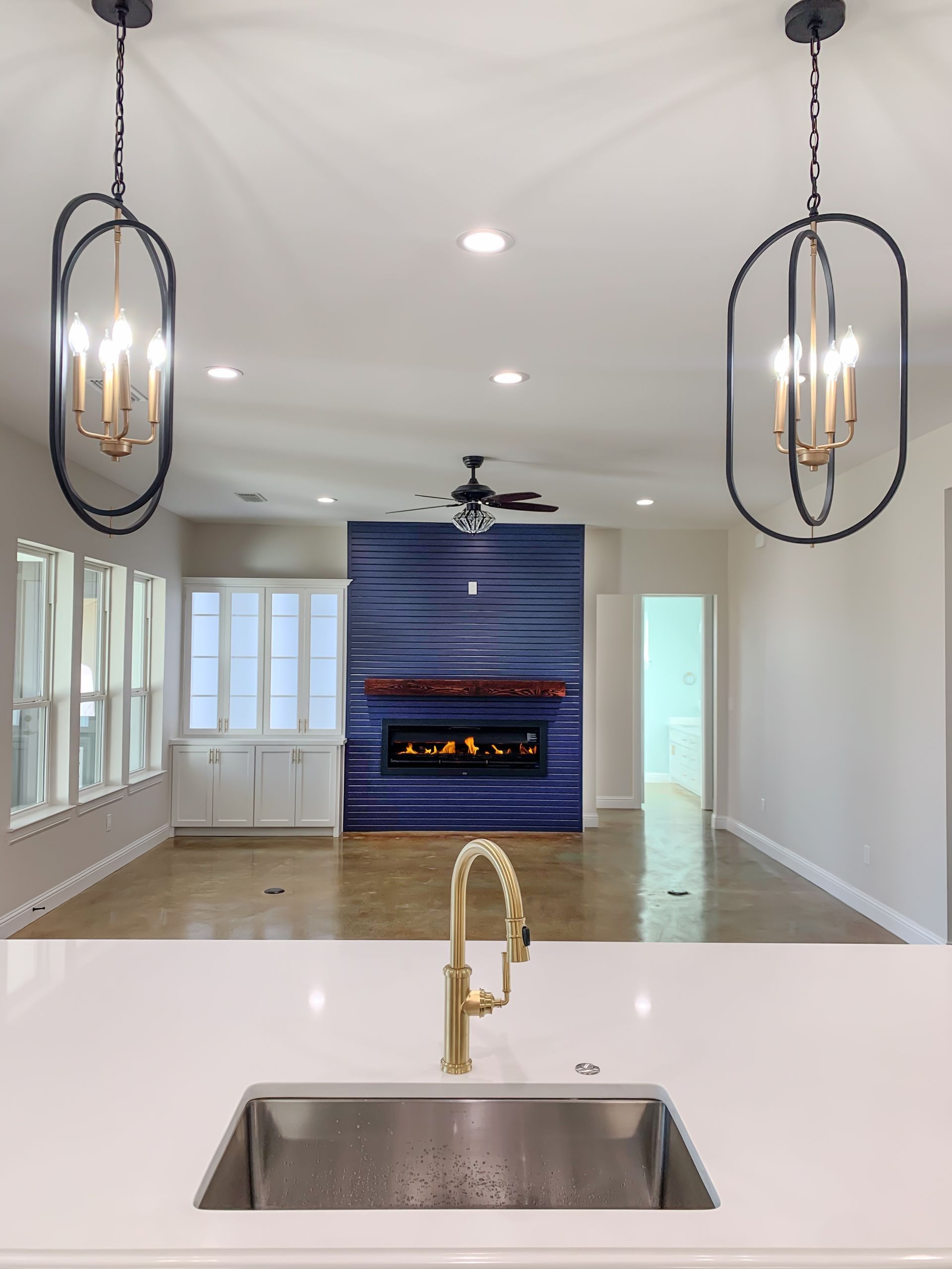 A kitchen with a sink and a fireplace in the background