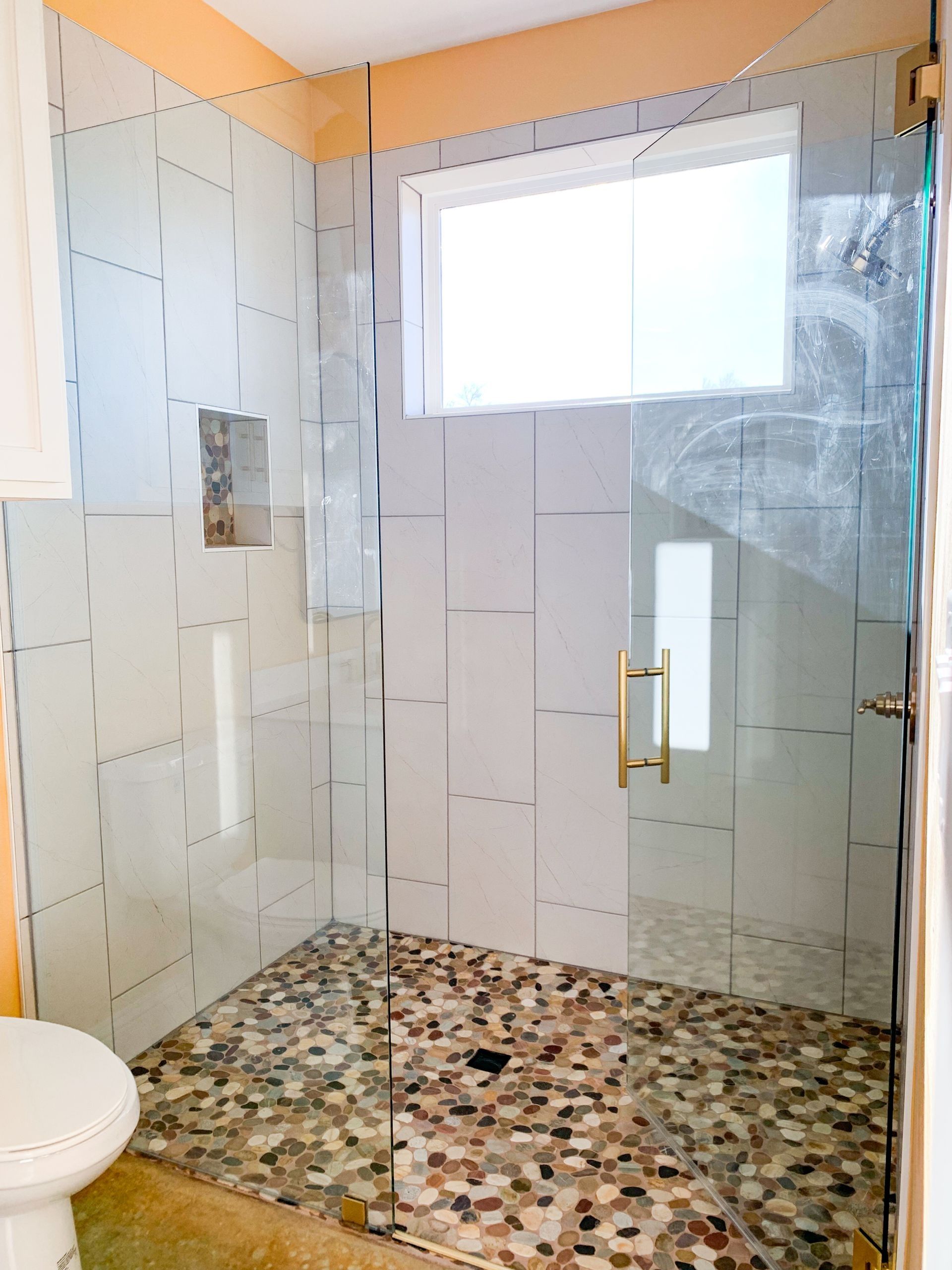 A bathroom with a walk-in shower and a toilet