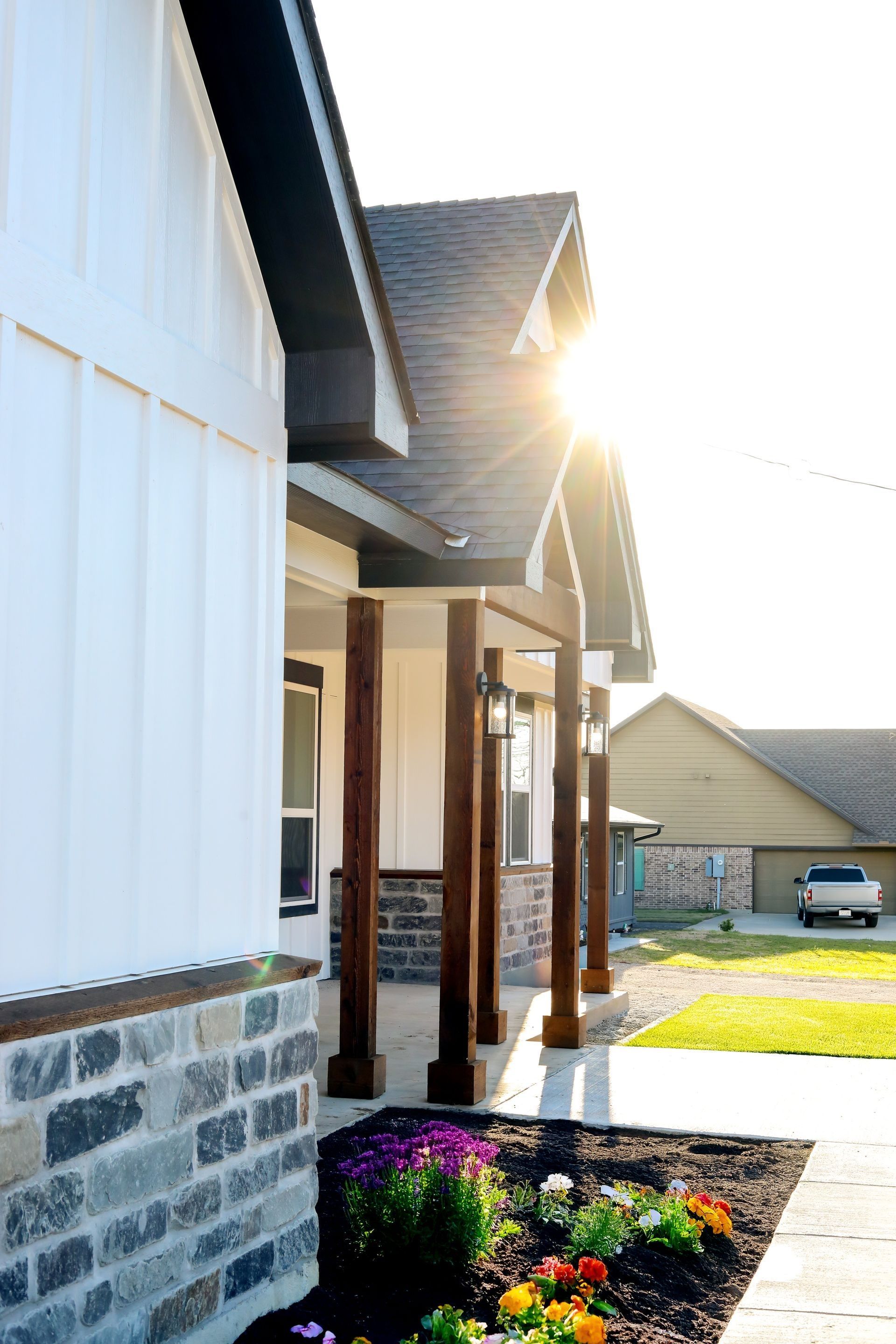 The sun is shining through the windows of a house with a porch