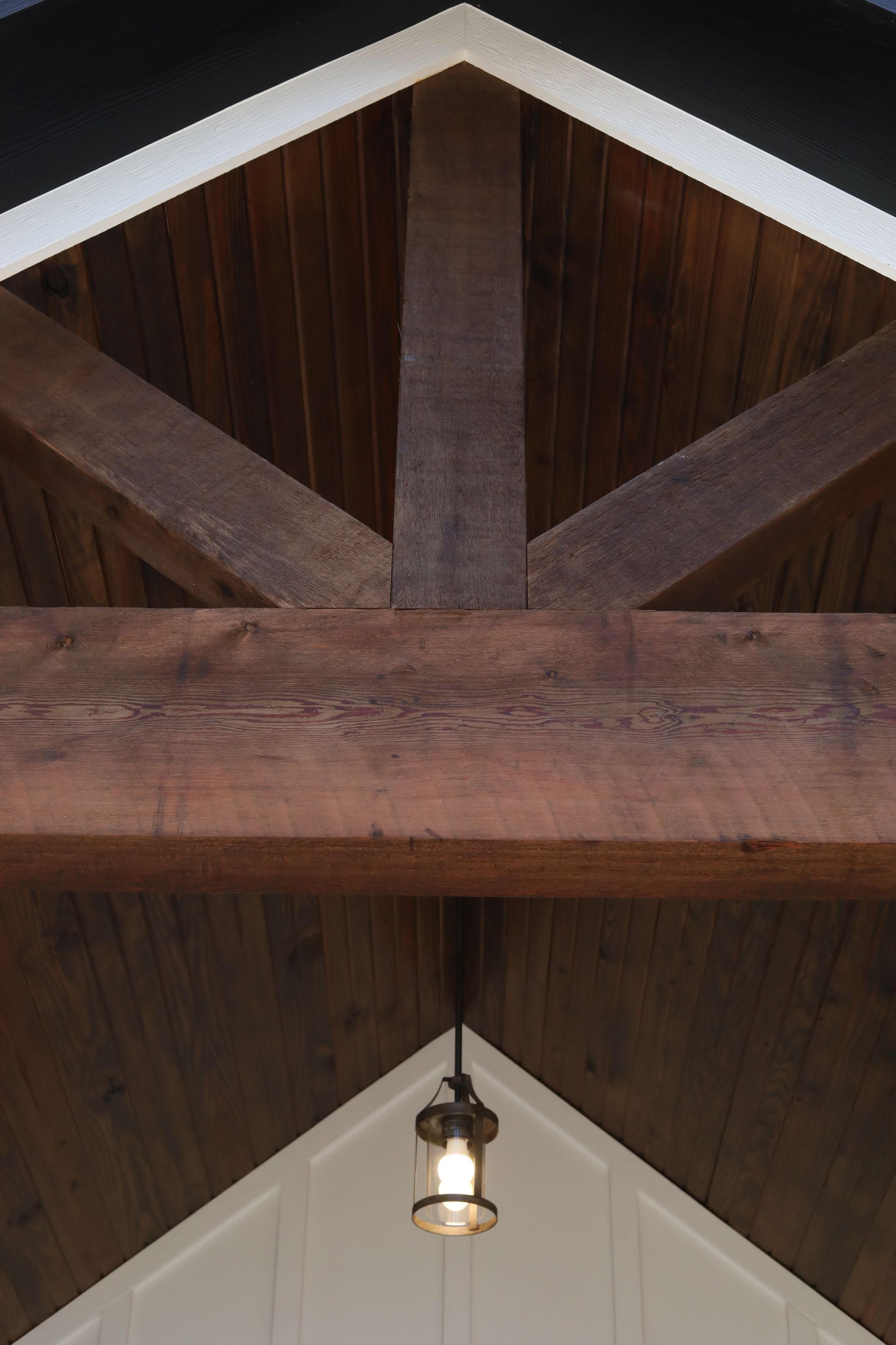 A wooden ceiling with a light hanging from it