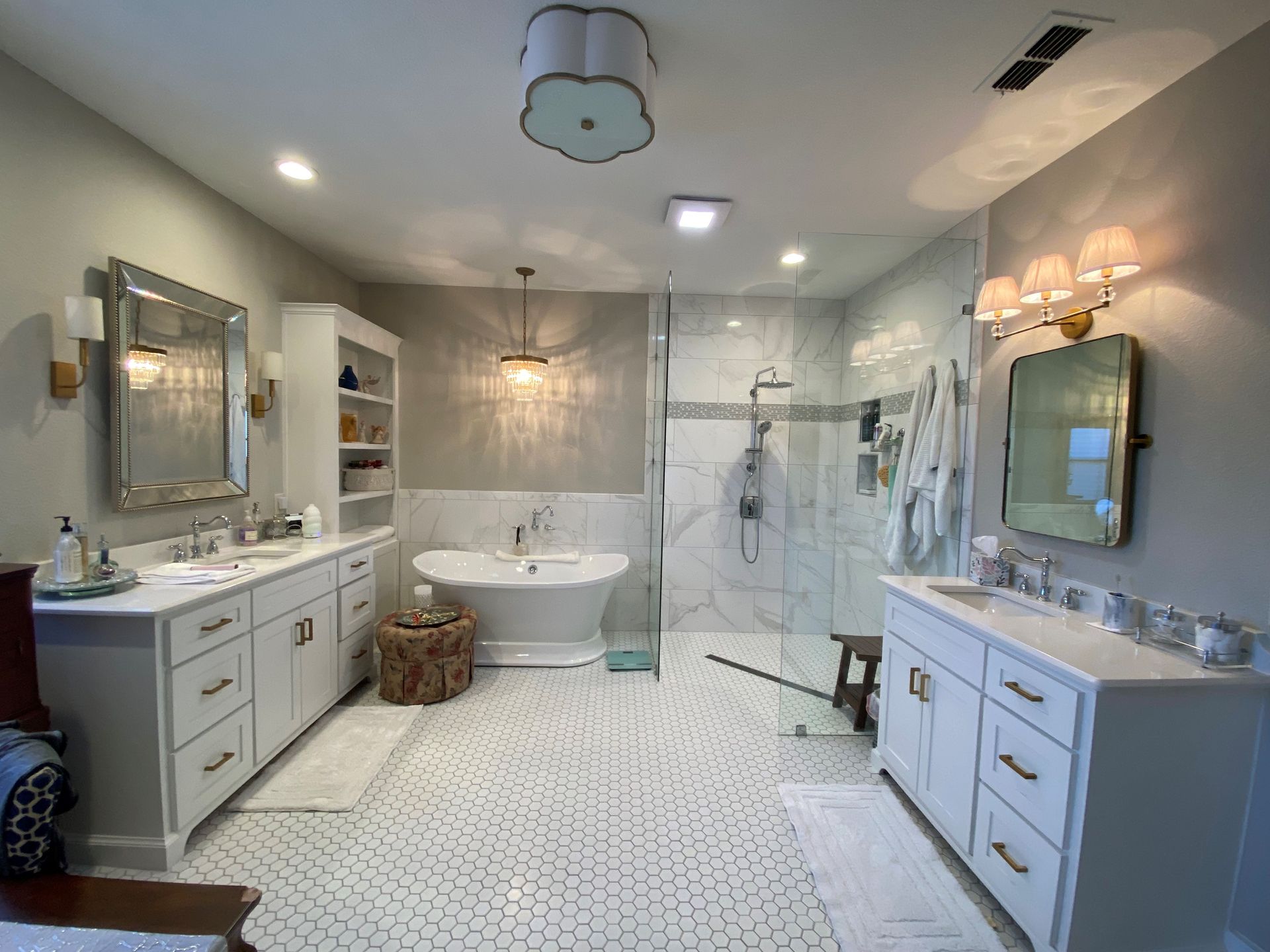 A bathroom with a bathtub , sinks , mirrors and a walk in shower.