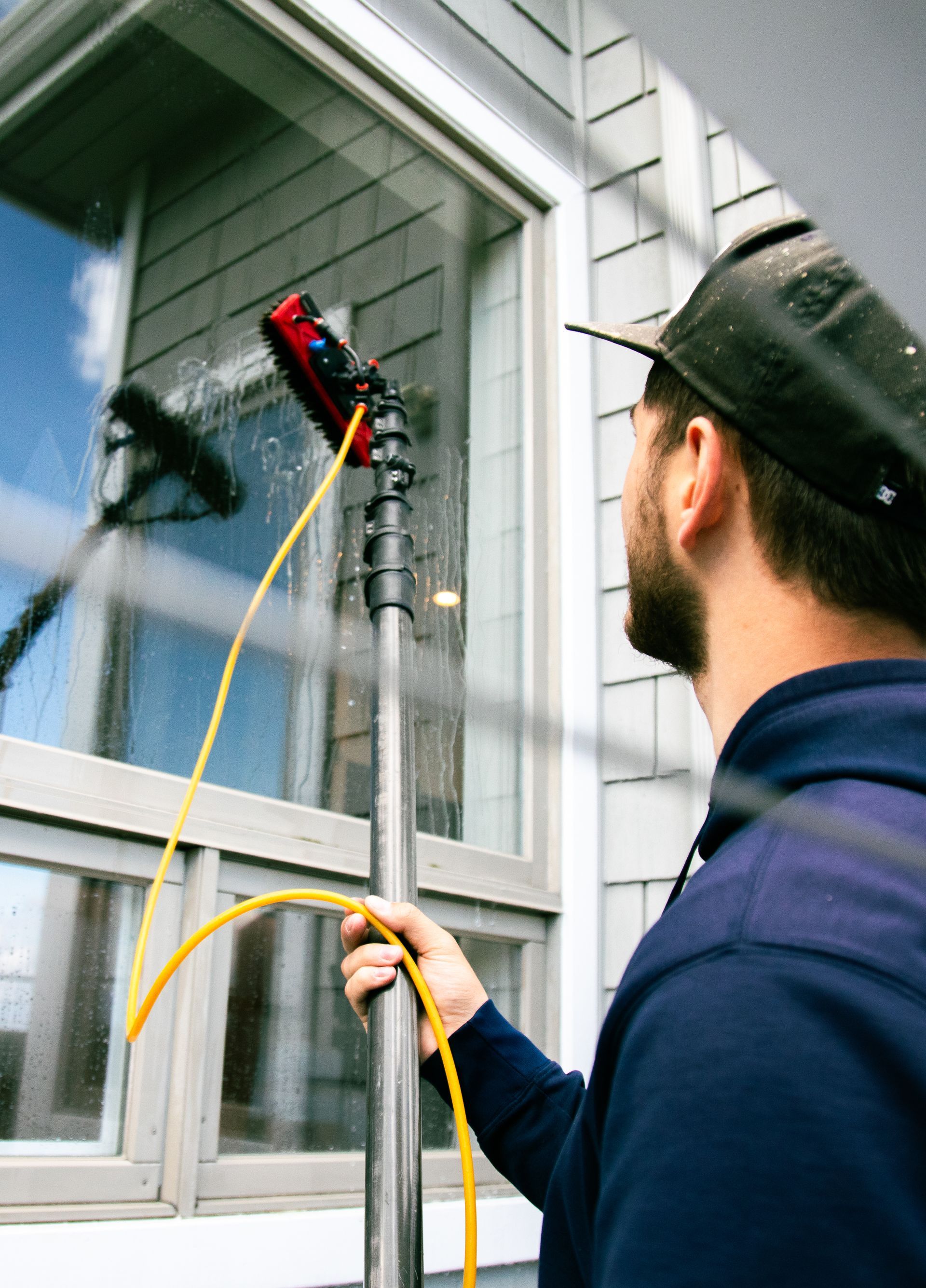 A man is cleaning the windows of a house.