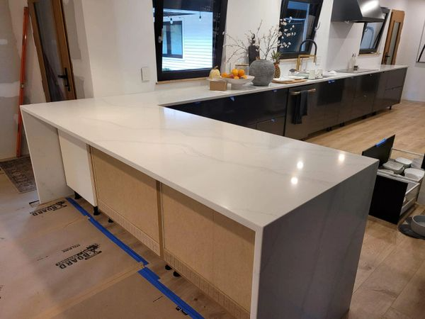 A kitchen with a white counter top and black cabinets