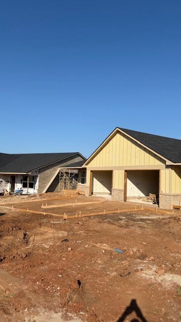 Two houses under construction with a clear blue sky background.