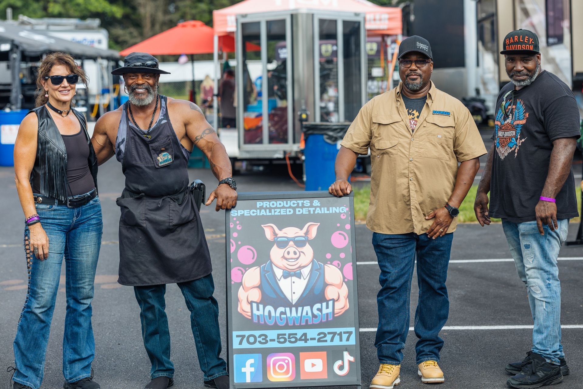 Four people pose with a sign for 