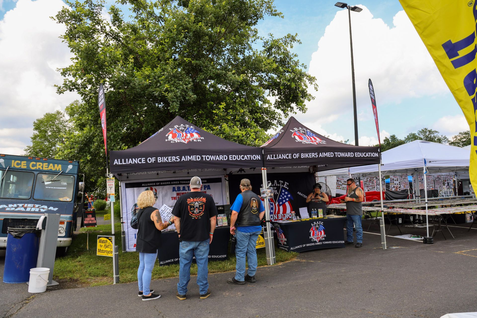 Event tents for veterans with people, an ice cream truck, and flags.