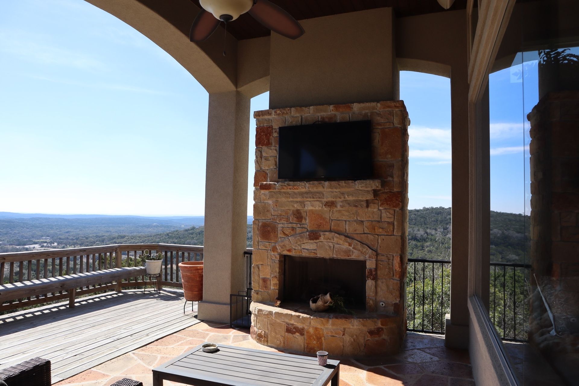 a patio with a fireplace and a flat screen tv