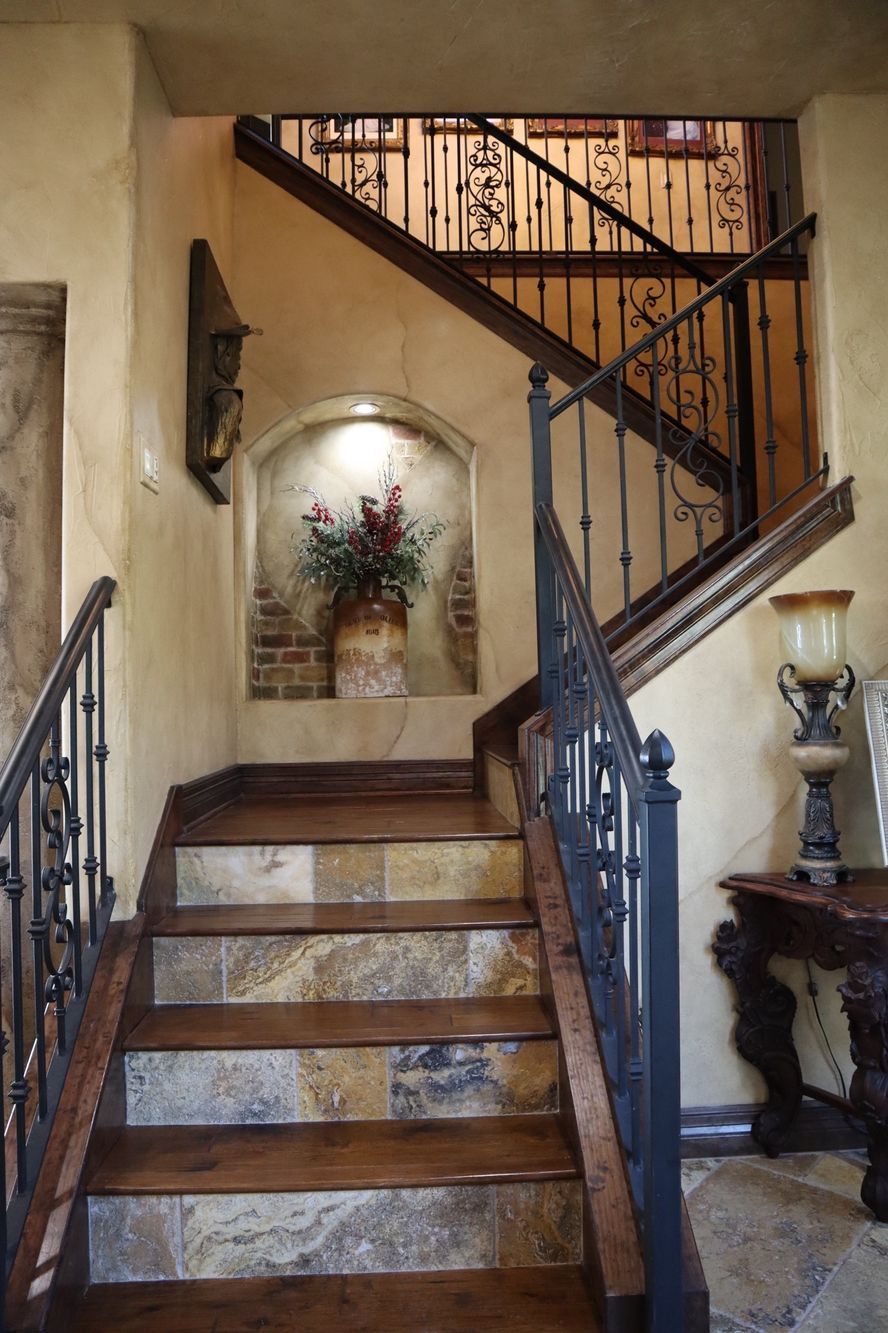 a wooden staircase with a wrought iron railing