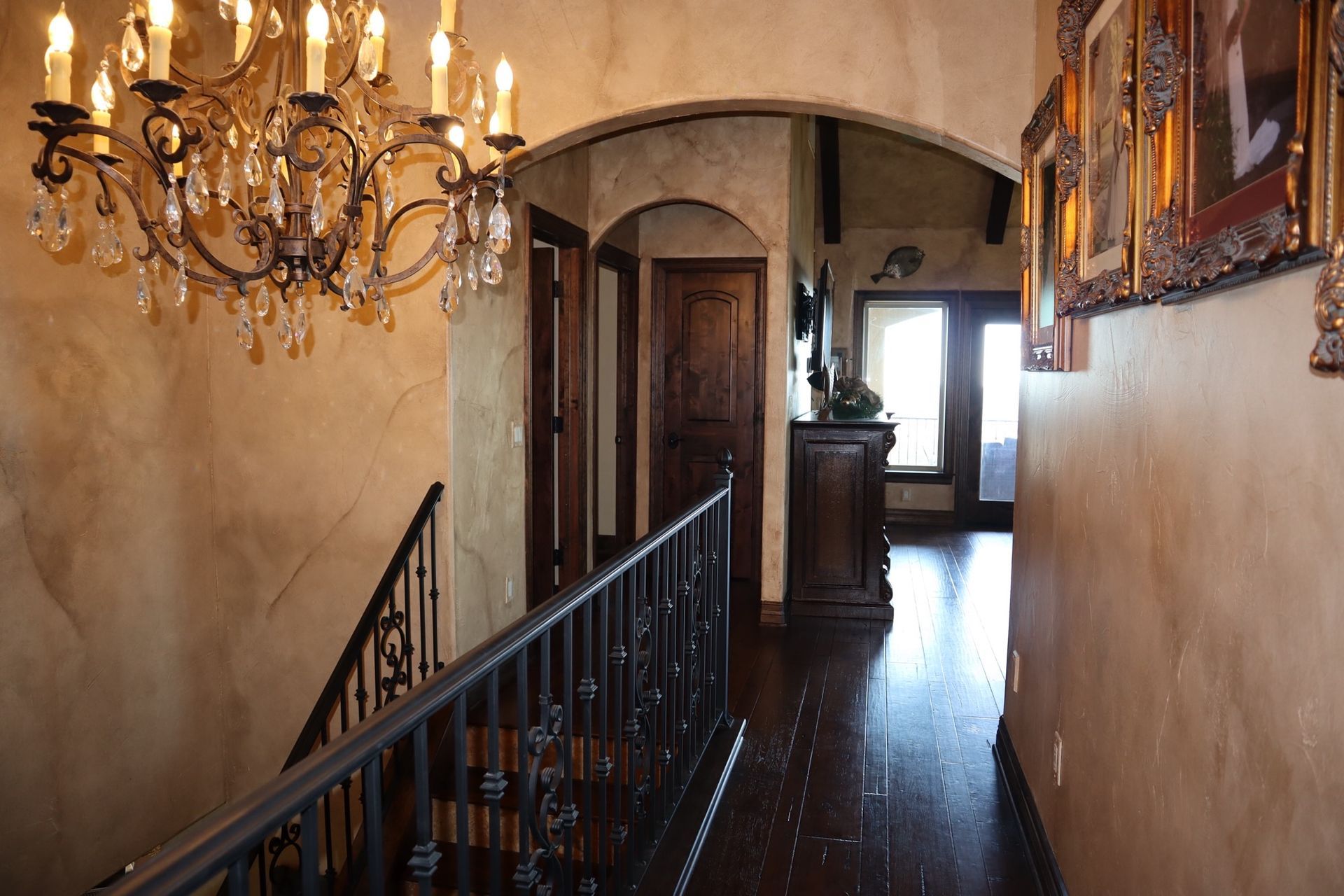 a hallway with stairs and a chandelier hanging from the ceiling