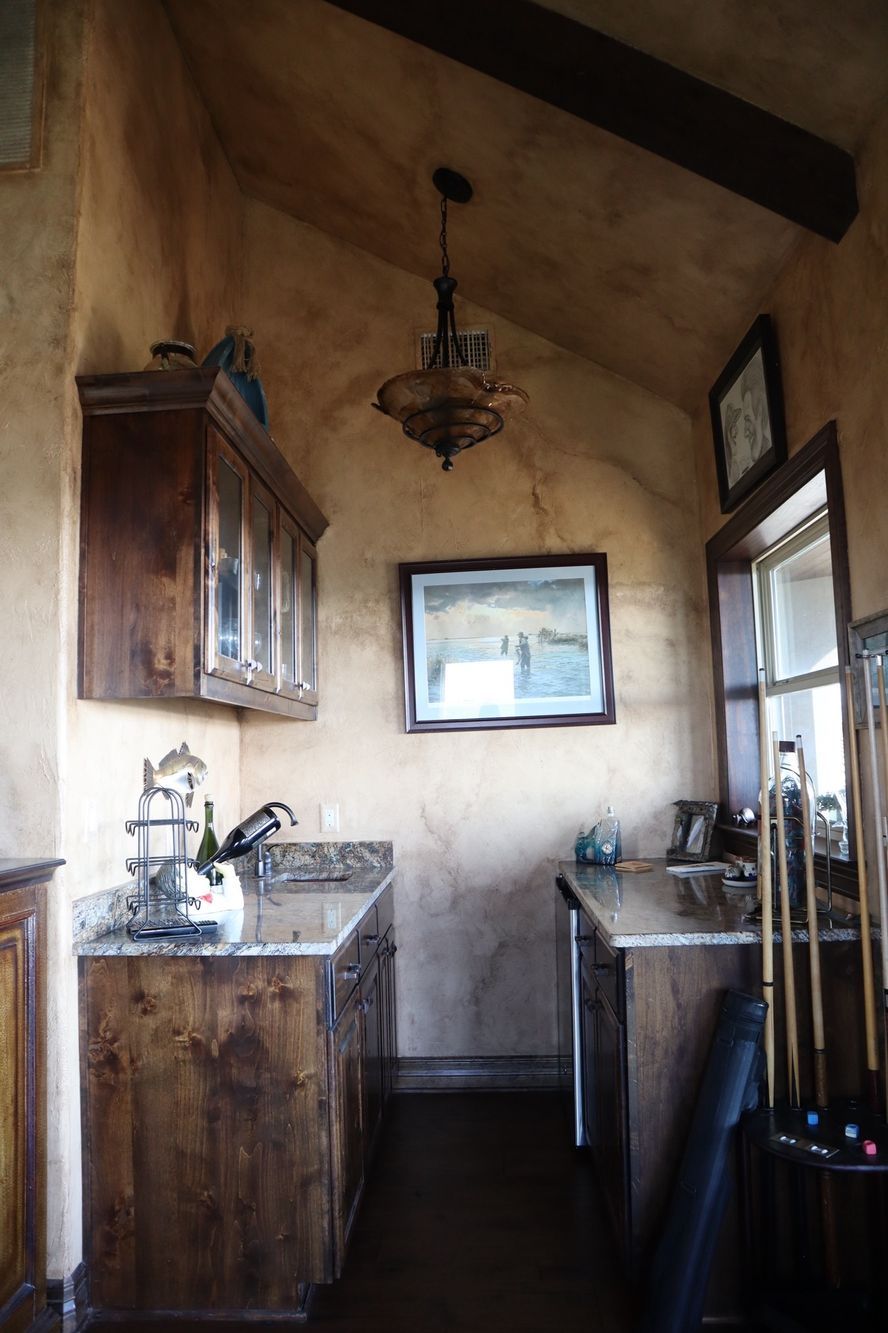 a kitchen with wooden cabinets and a picture on the wall