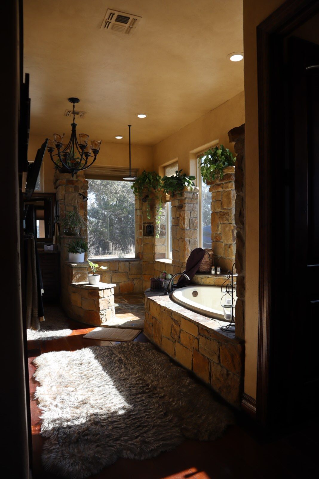 a bathroom with a tub and a chandelier hanging from the ceiling