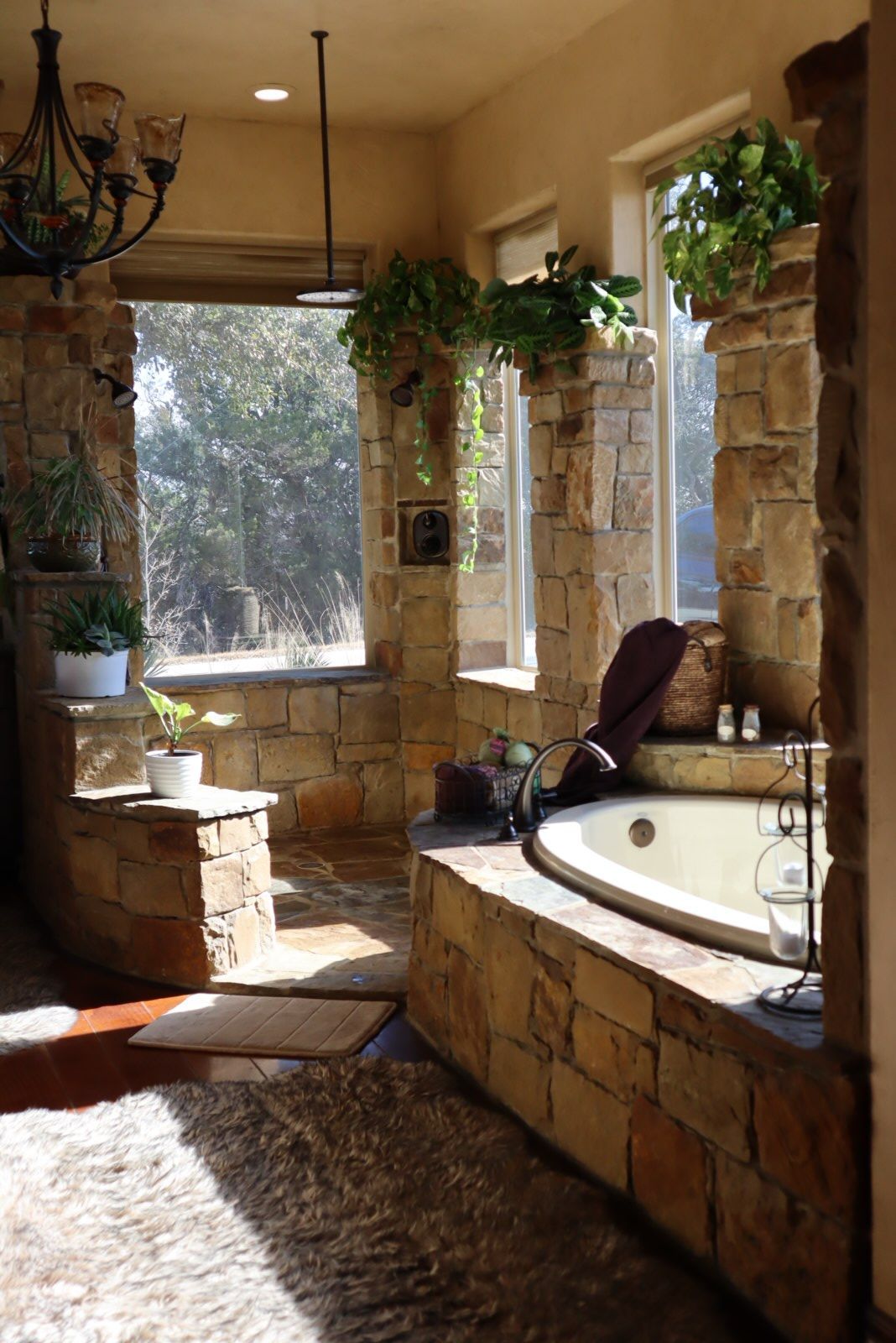 a bathroom with a jacuzzi tub surrounded by stone walls and windows