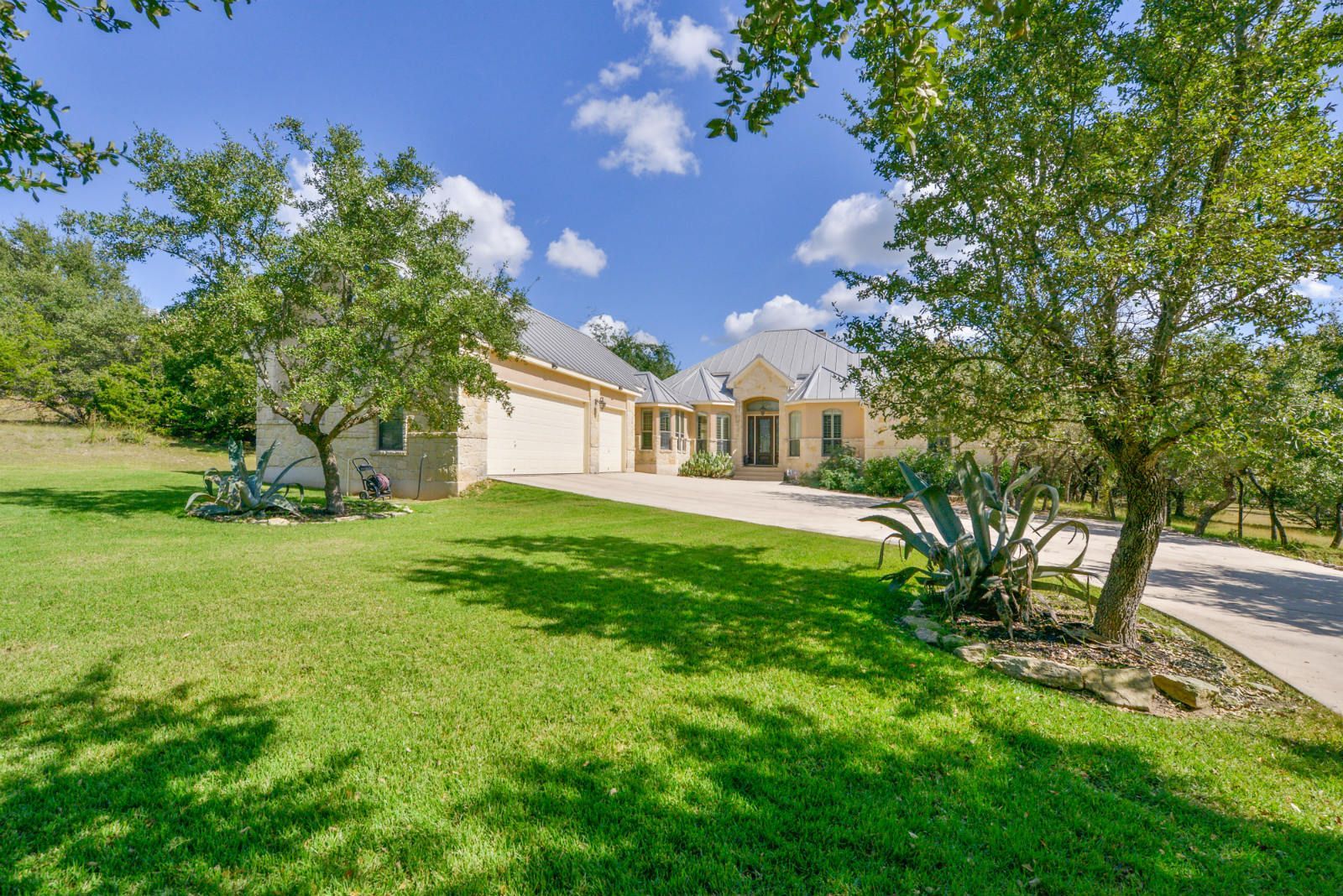 A large house with a lot of grass and trees in front of it