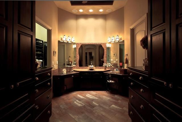 A walk in closet with lots of drawers and a large mirror