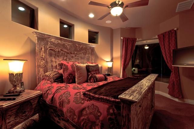 A bedroom with a large bed and a ceiling fan