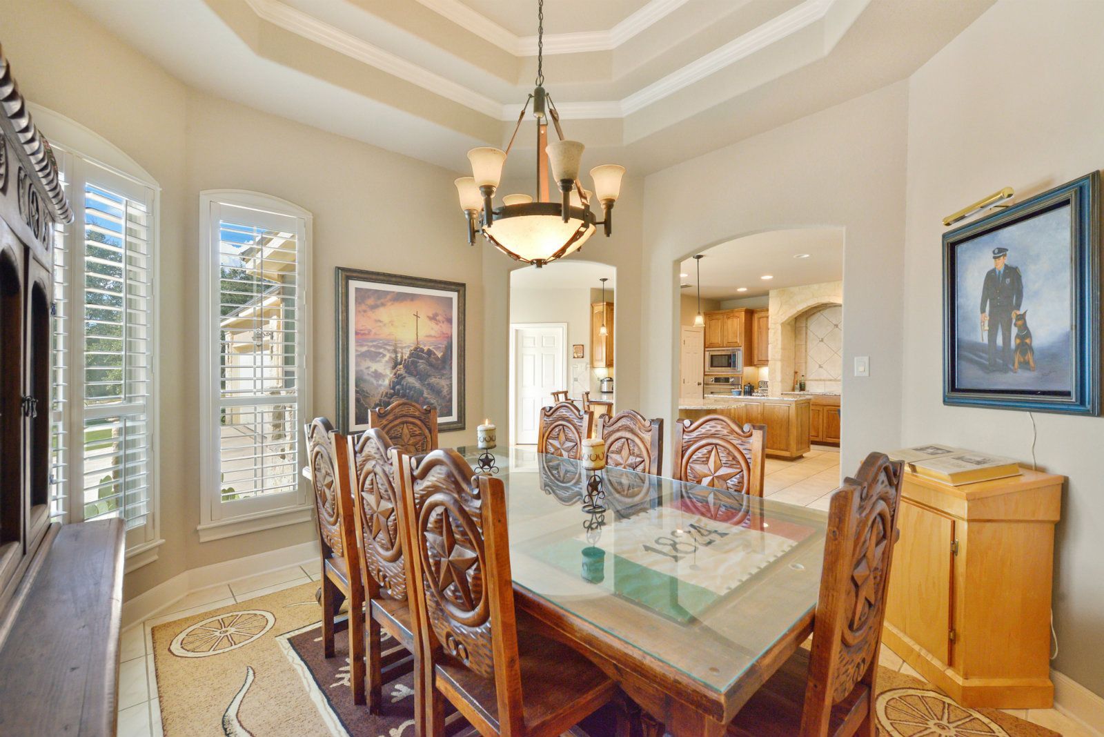 A dining room with a table and chairs and a chandelier hanging from the ceiling