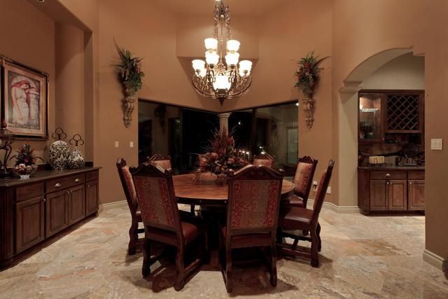 A dining room with a table and chairs and a chandelier