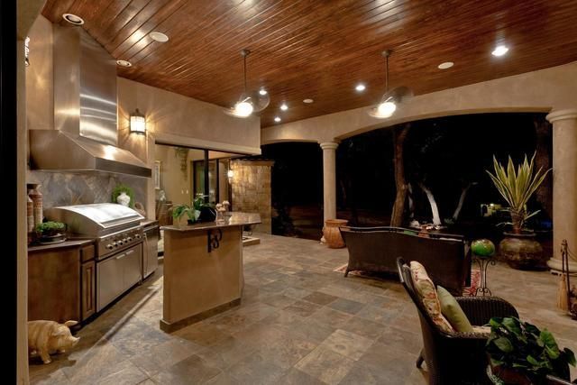 A kitchen with a wooden ceiling and stainless steel appliances