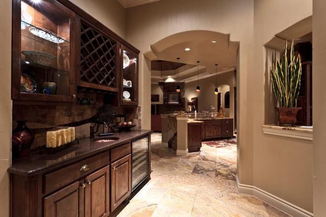 A hallway in a house with wooden cabinets and a wine rack