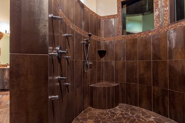 A bathroom with brown tiles and a walk in shower