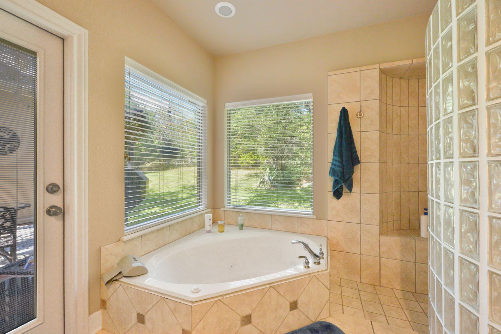 A bathroom with a corner tub and a window