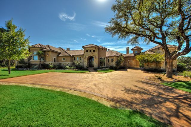 A large house with a dirt driveway leading to it