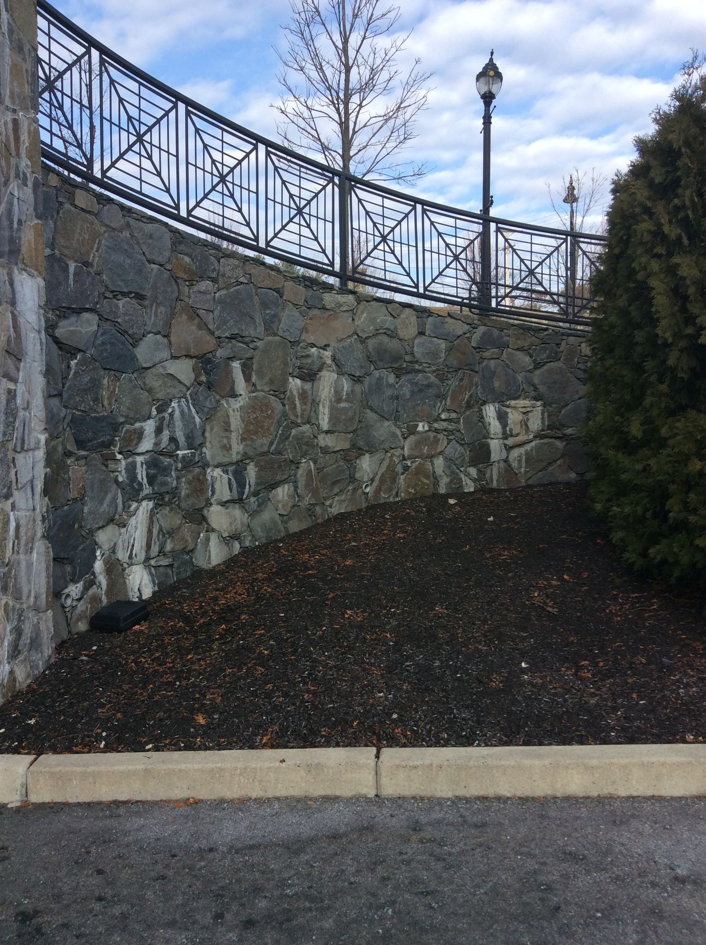 a stone wall with a wrought iron fence around it