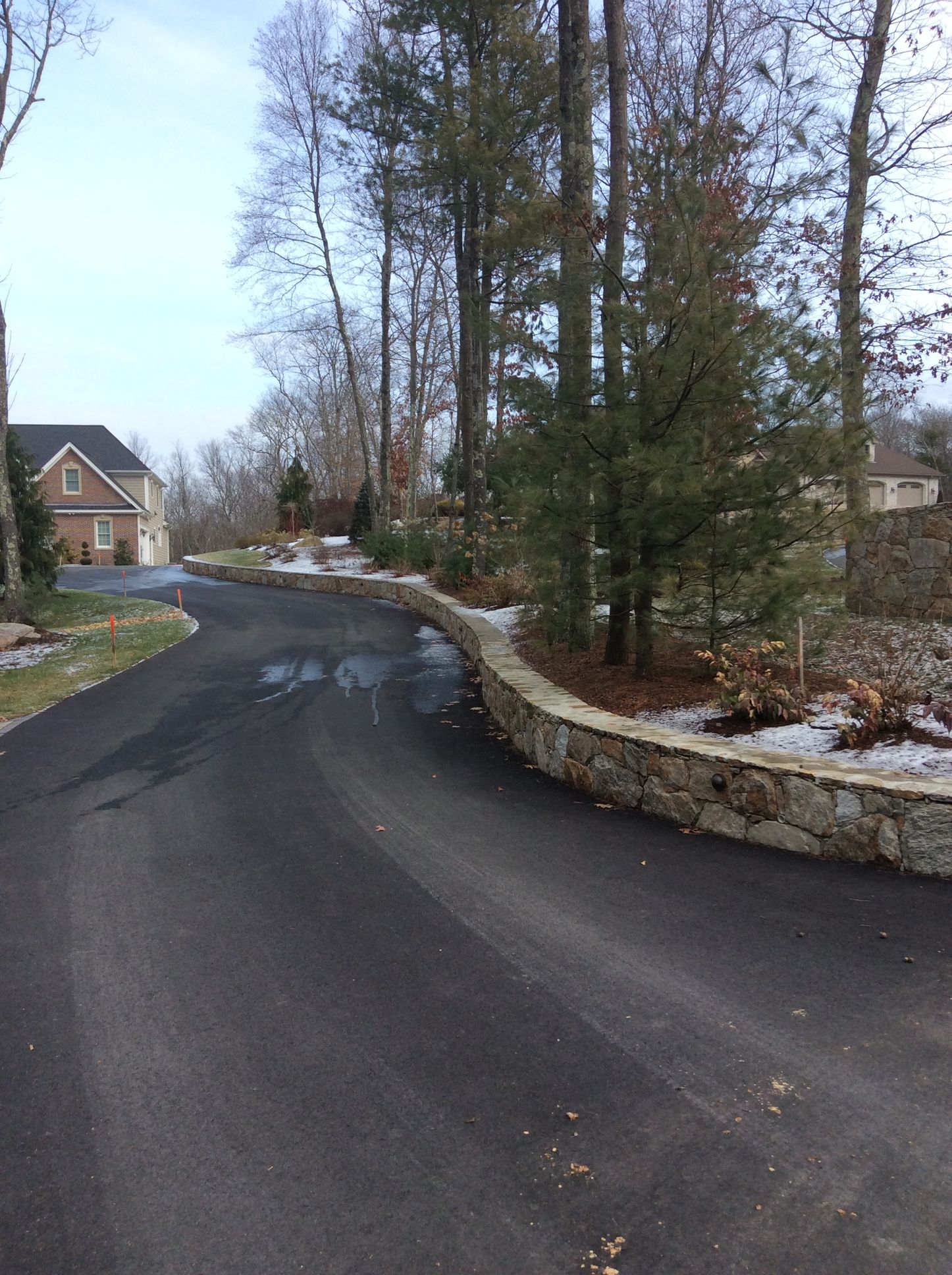 there is a stone wall on the side of the road