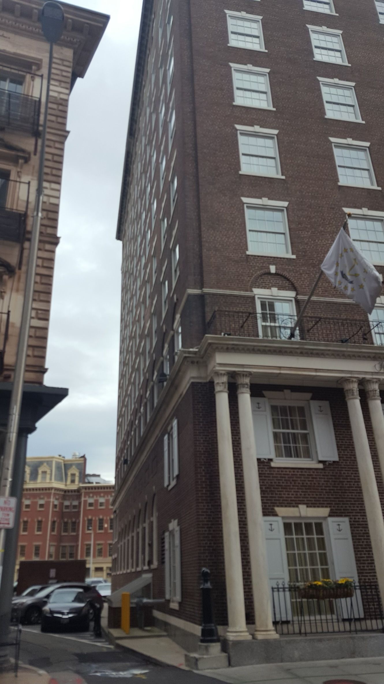 a tall brick building with white shutters on the windows