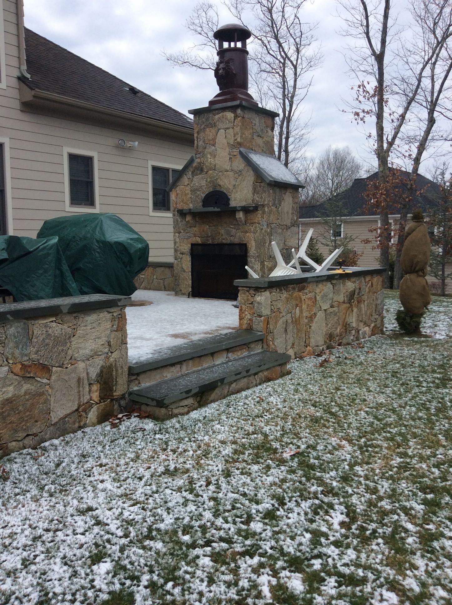 a man is standing in front of a stone fireplace in the snow