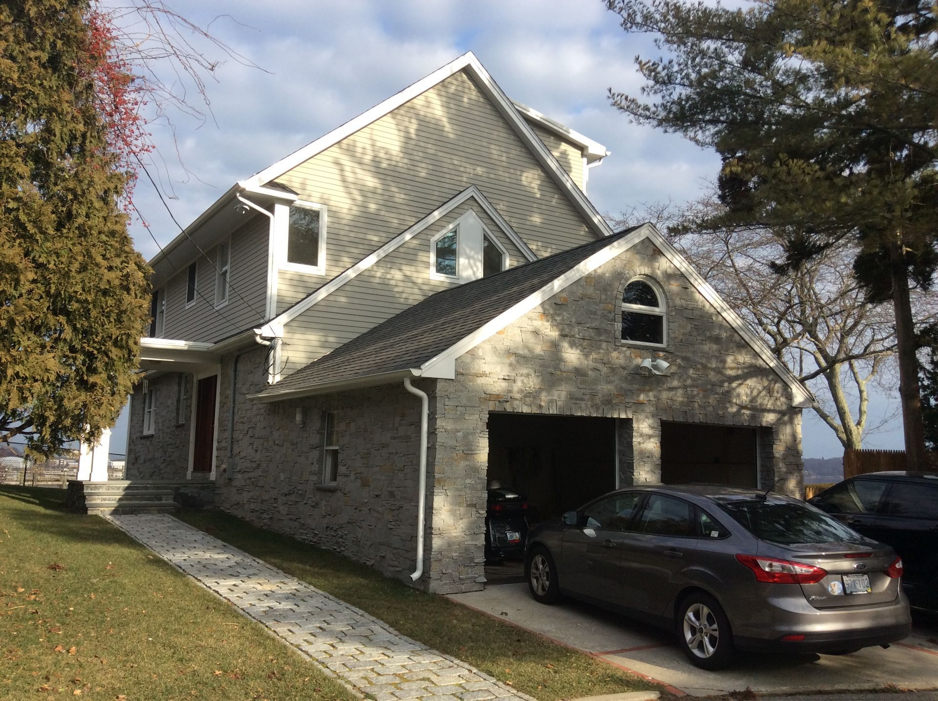 a car is parked in front of a house with a garage