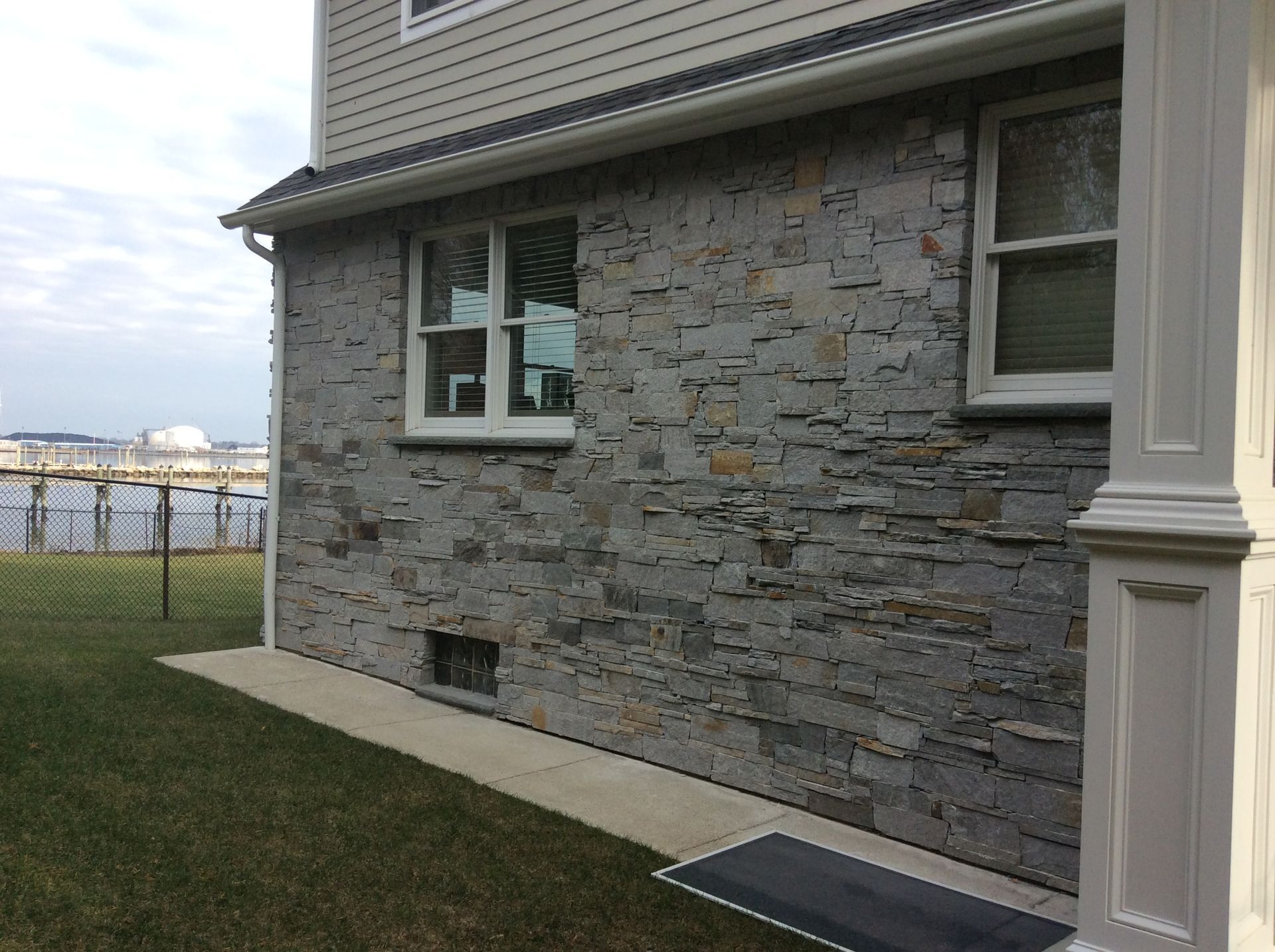 the side of a house with a stone wall and a window