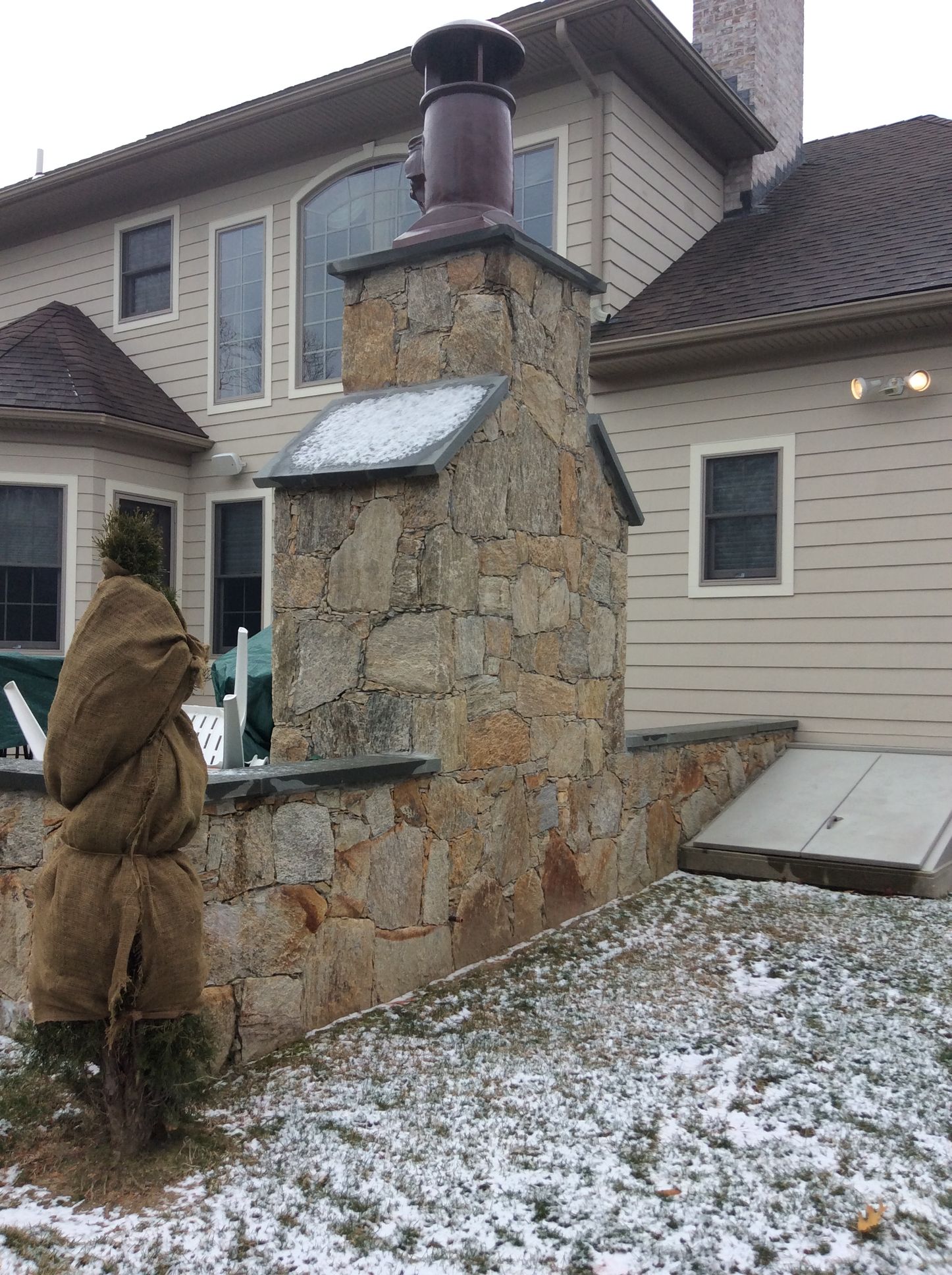 a large house with a stone chimney in front of it