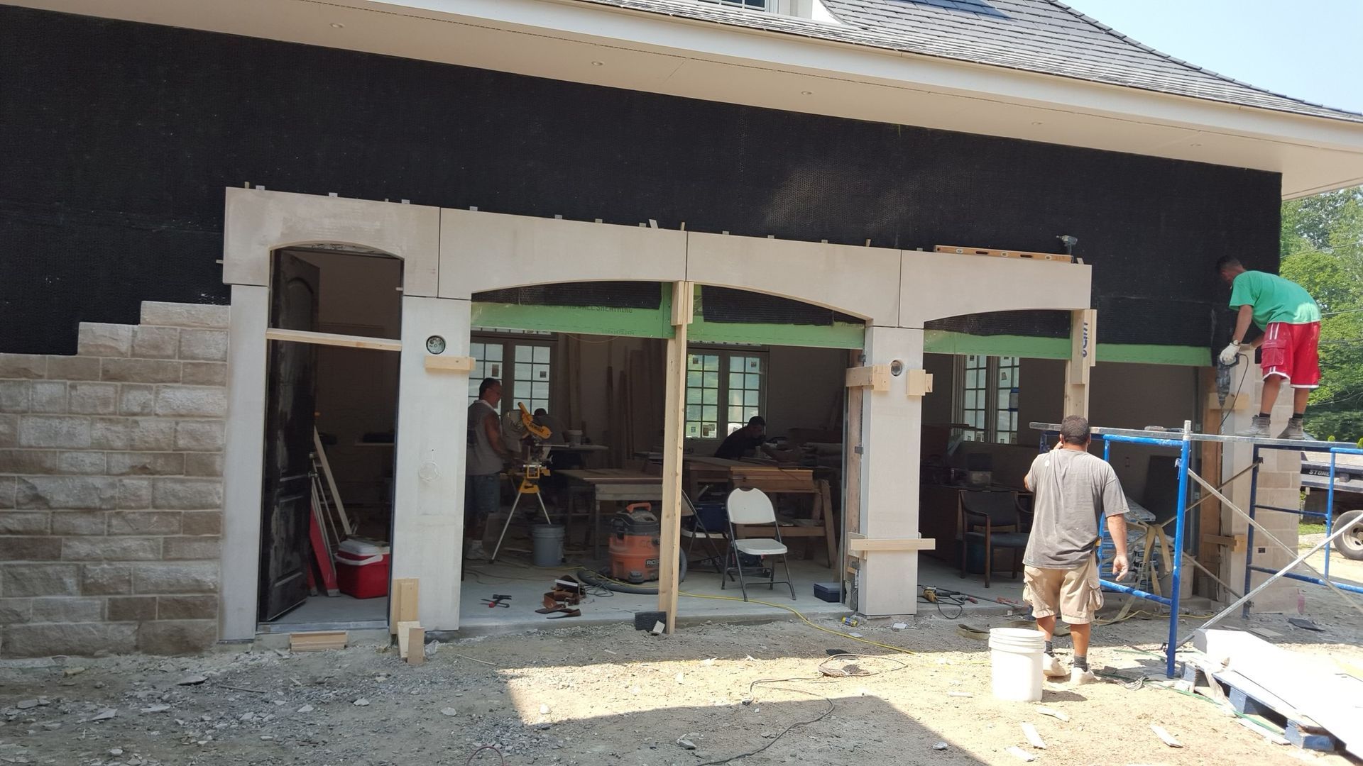 a man is standing on a ladder in front of a building under construction