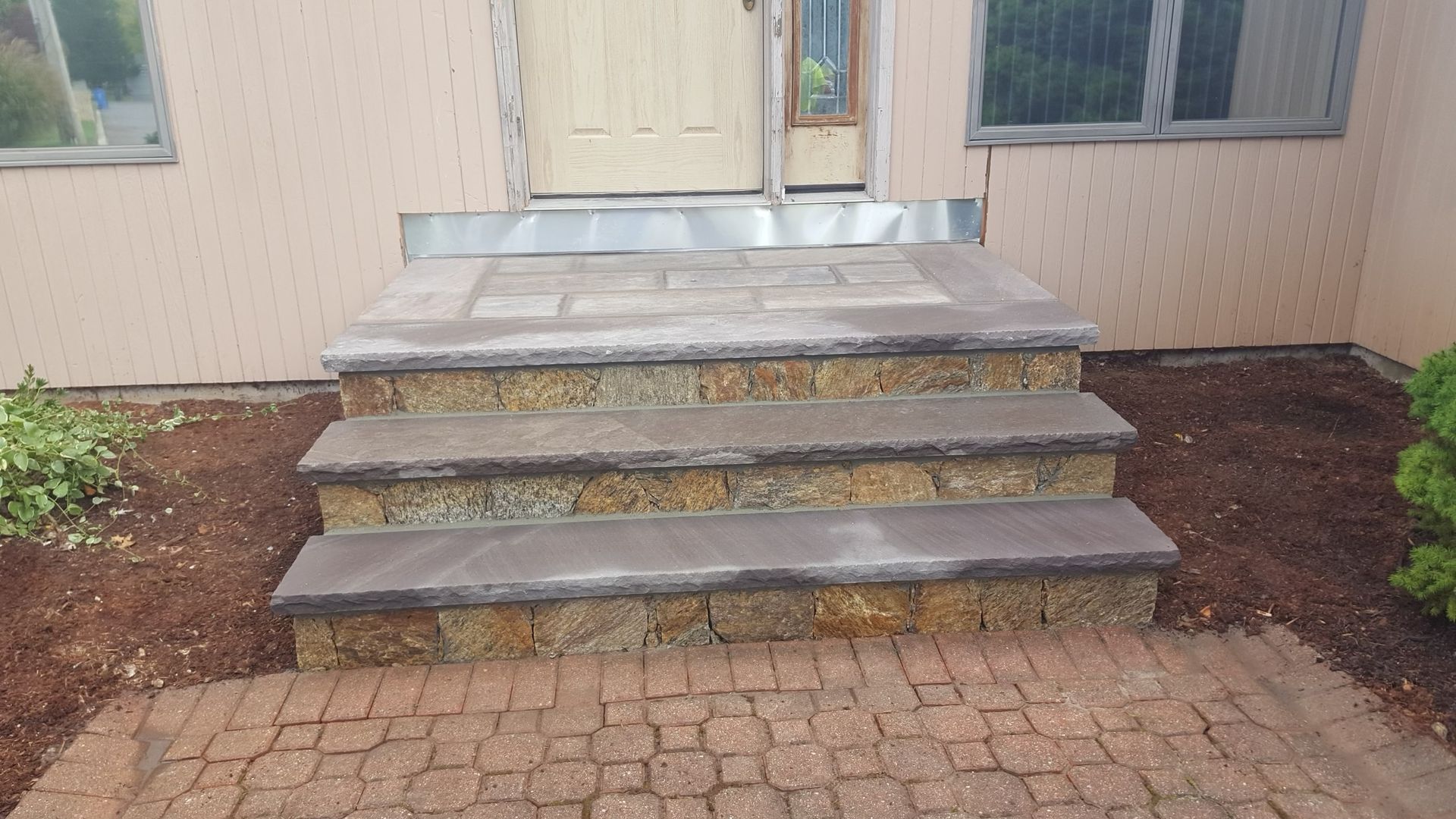 a set of stone steps leading up to the front door of a house