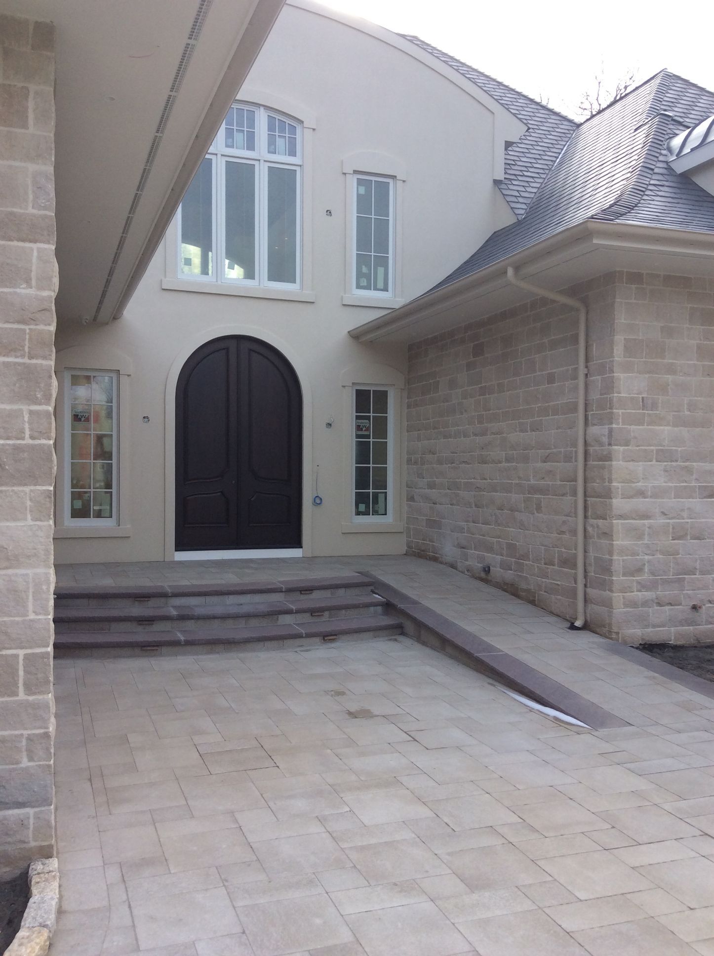 a large brick house with a black door and white windows