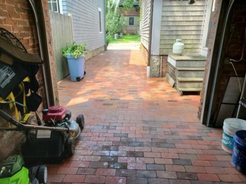 a lawn mower is parked in a garage next to a brick walkway
