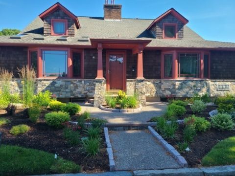 a large house with a gray roof and a red door