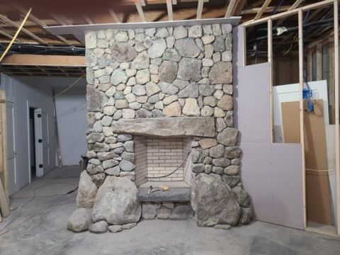 a stone fireplace in a room under construction