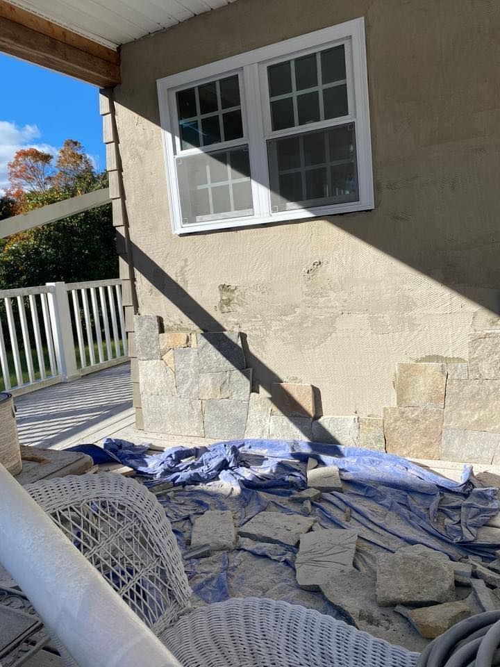 a wicker chair is sitting on the ground in front of a house with a window