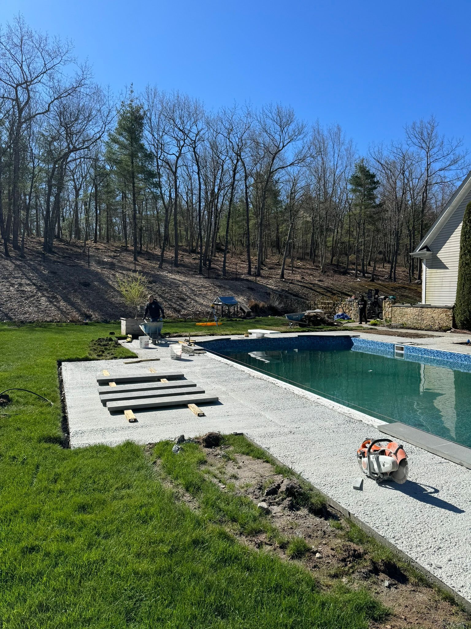 A swimming pool is being built in the backyard of a house