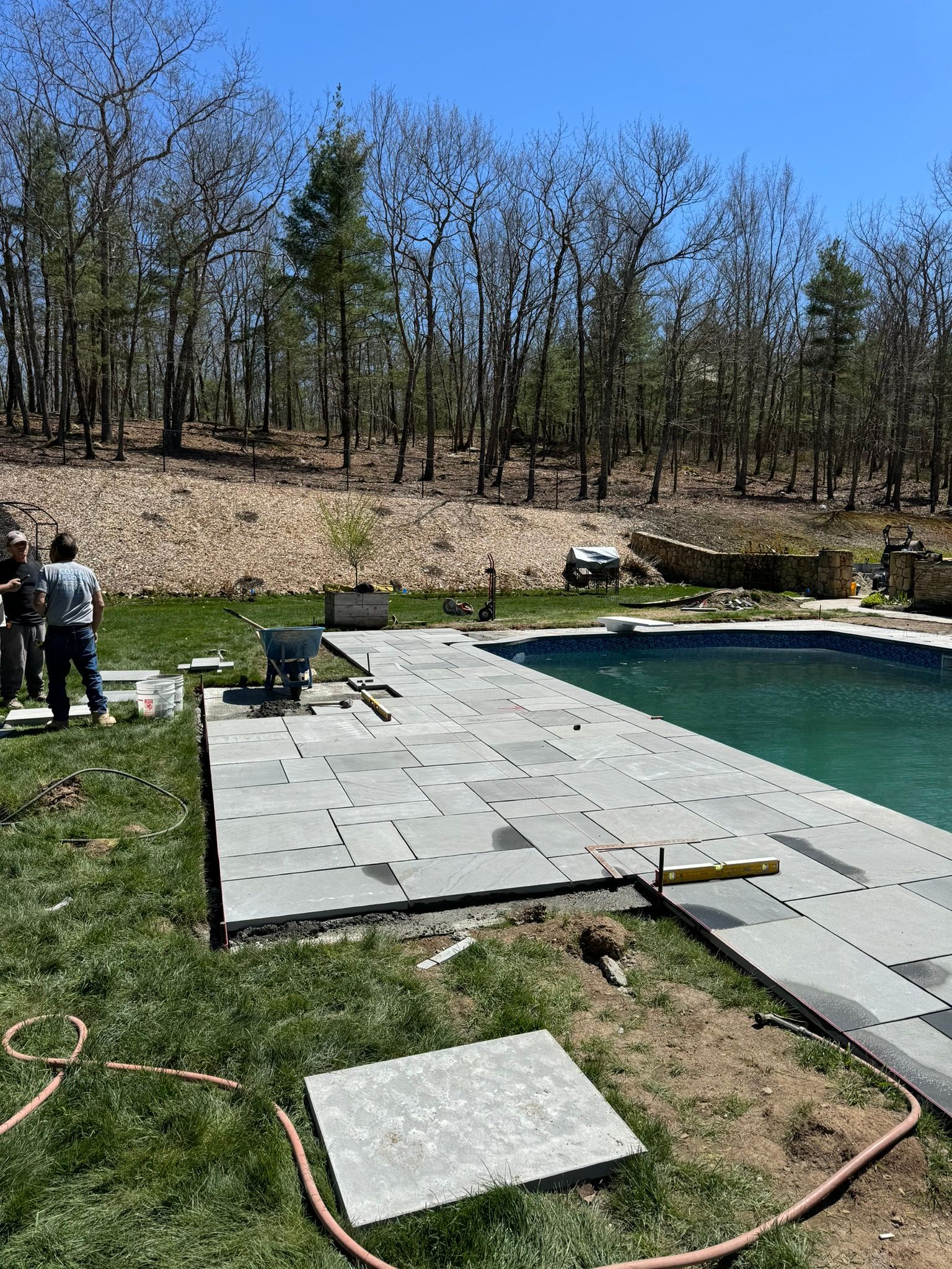 A swimming pool is being built in the backyard of a house