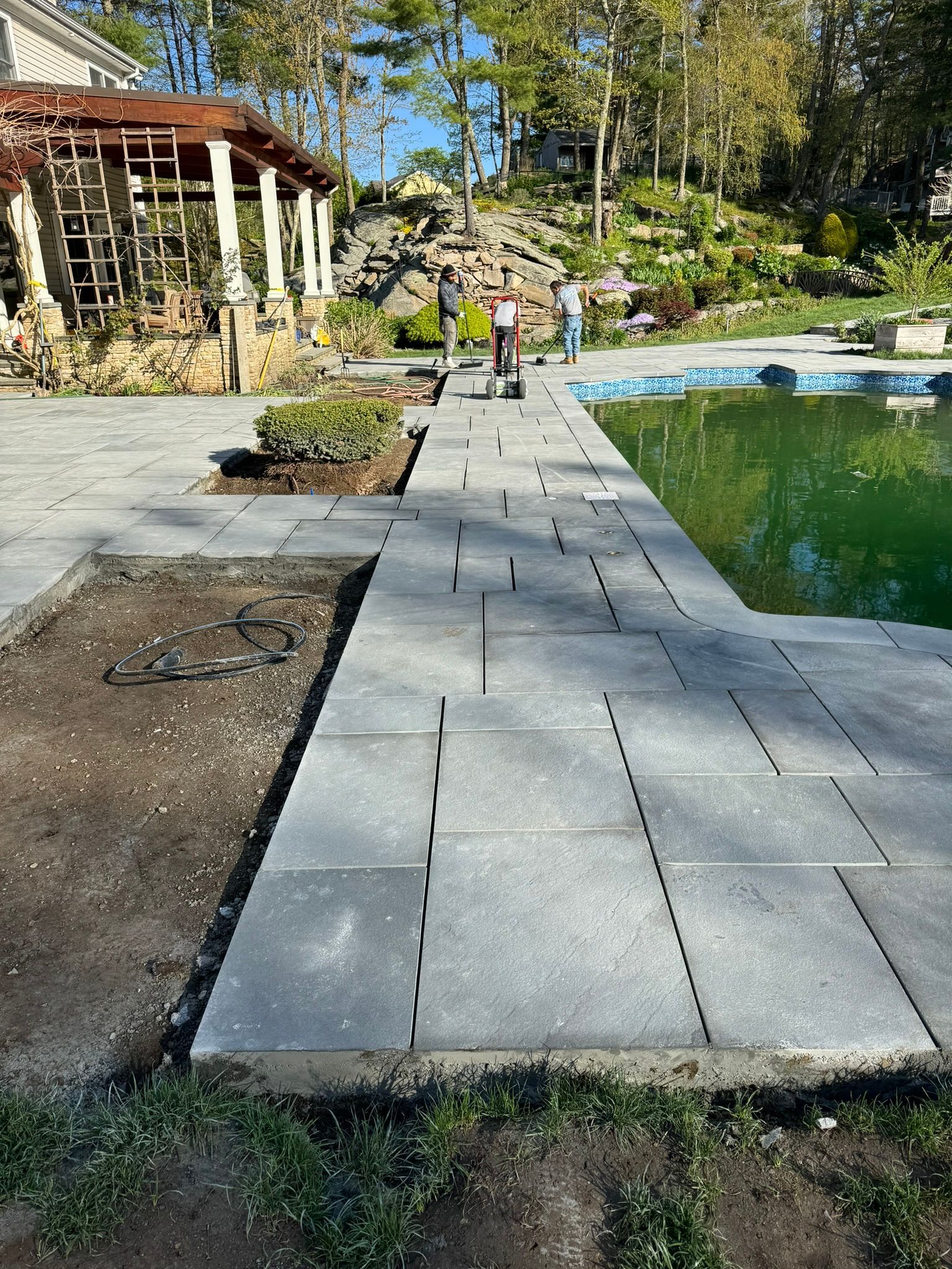 A concrete walkway leading to a pool in a backyard