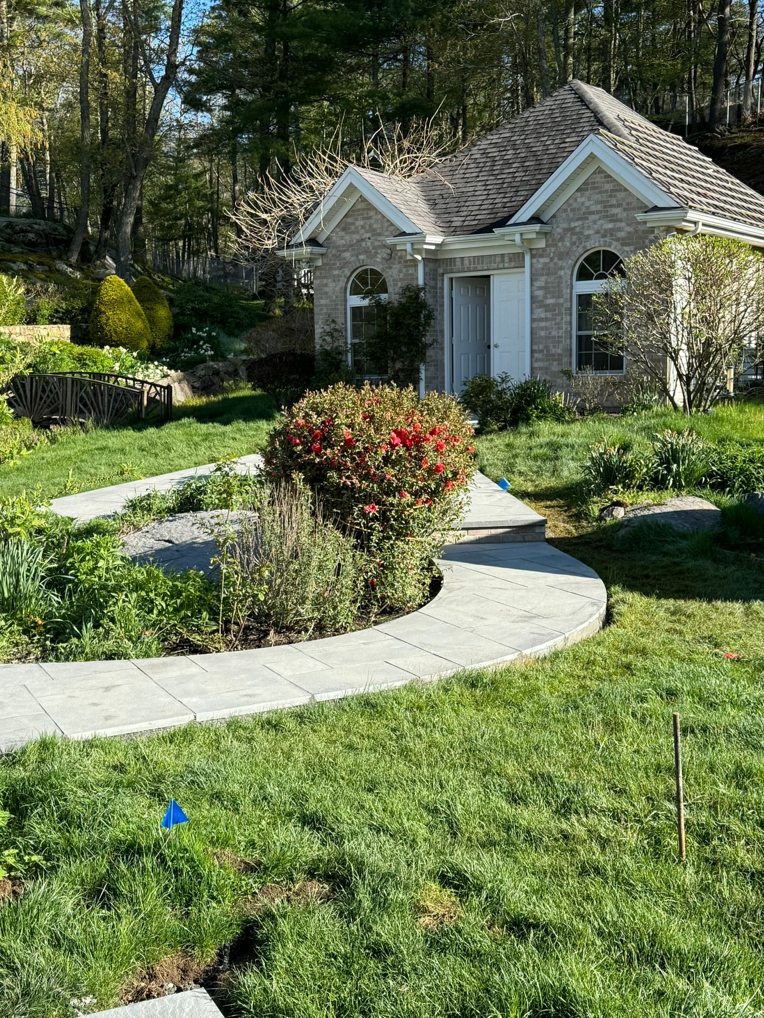 A brick house with a lush green lawn and a walkway leading to it