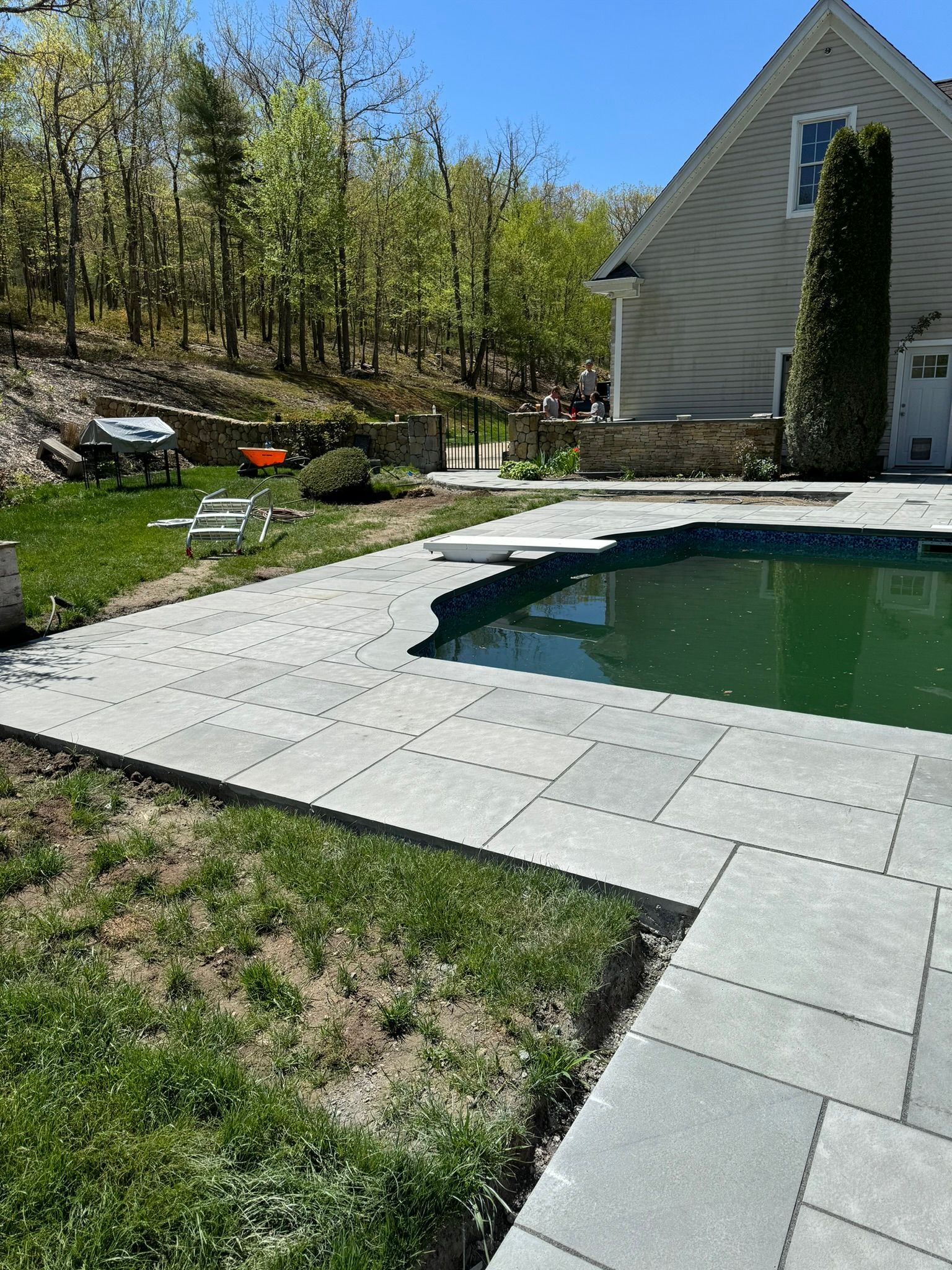 There is a swimming pool in the backyard of a house