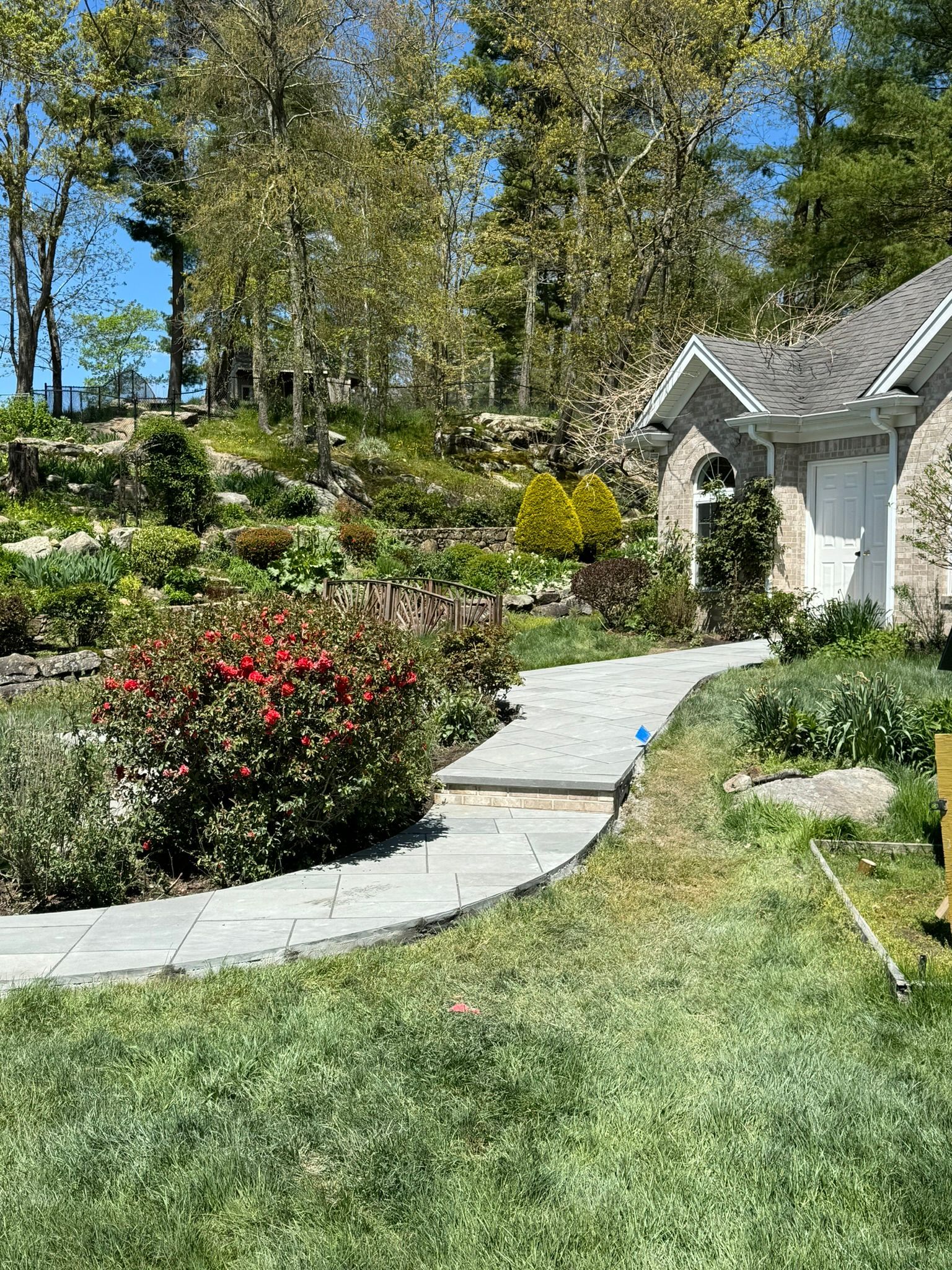 There is a path leading to a house in the middle of a garden