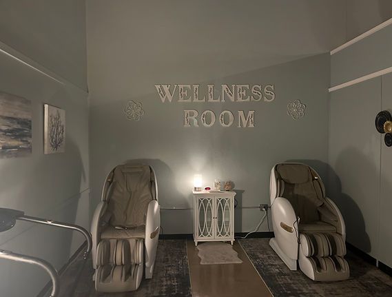 Wellness room with two massage chairs, small table, and