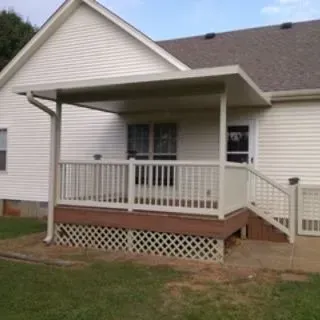 Covered back porch with railing and steps on a home with siding.