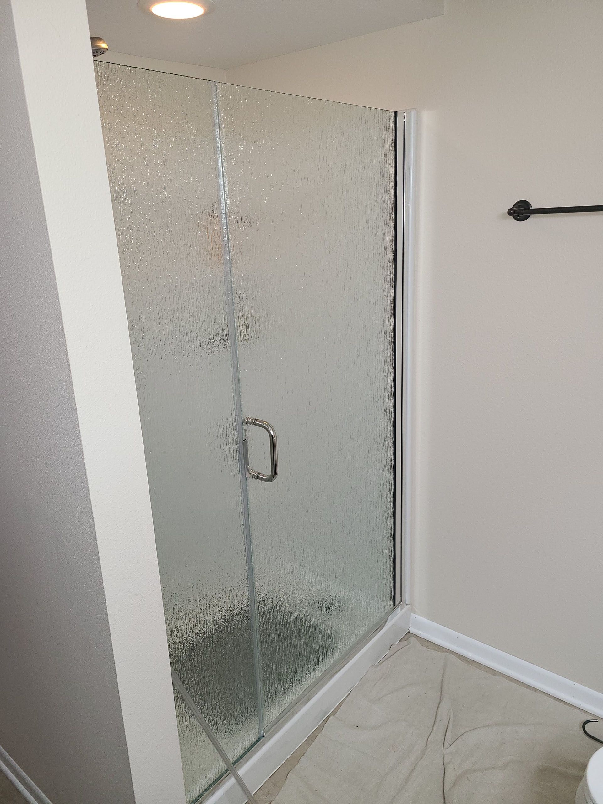 Door and panel - A bathroom with a shower stall and a toilet.