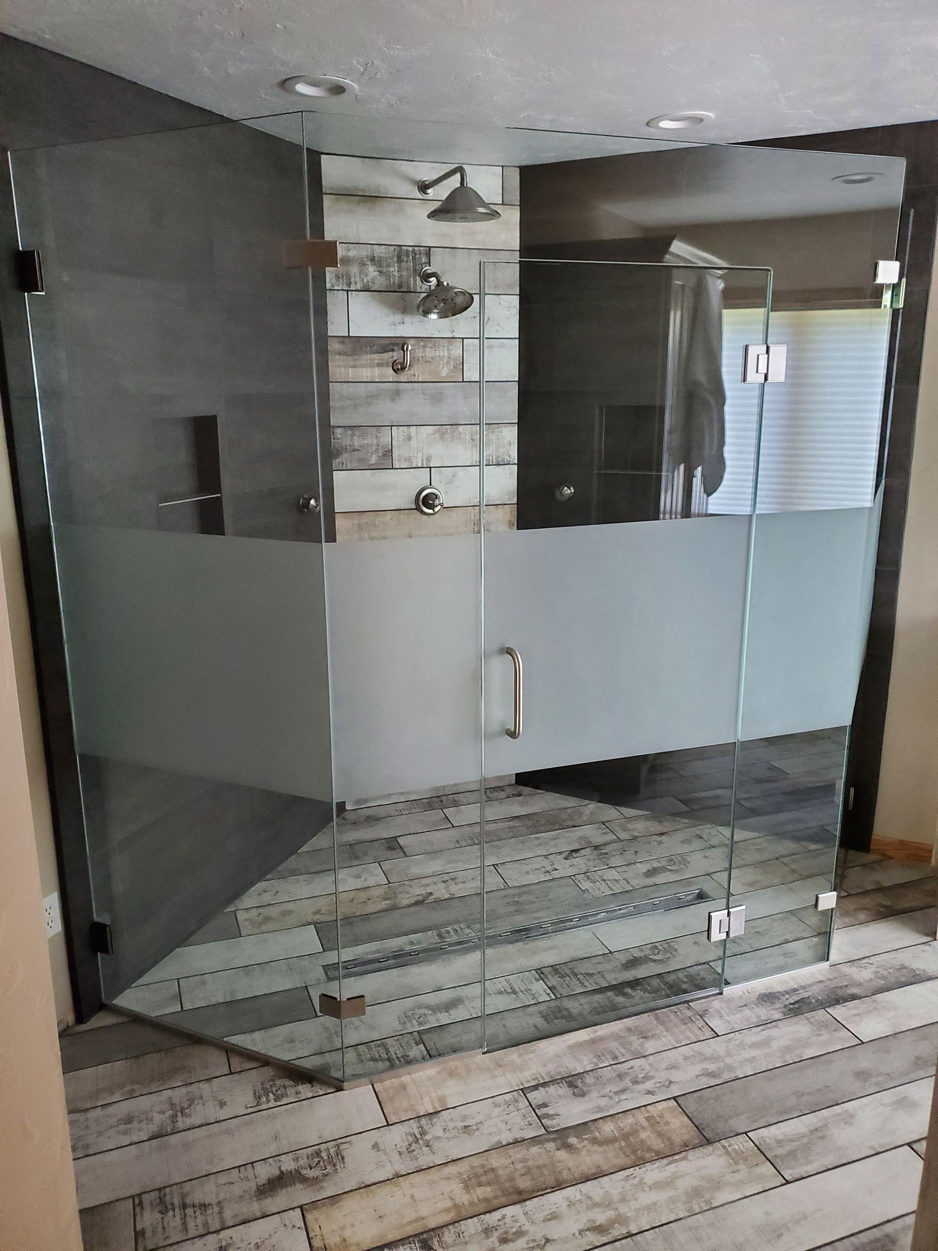 Multiple panels - A bathroom with a glass shower door and a wooden floor.